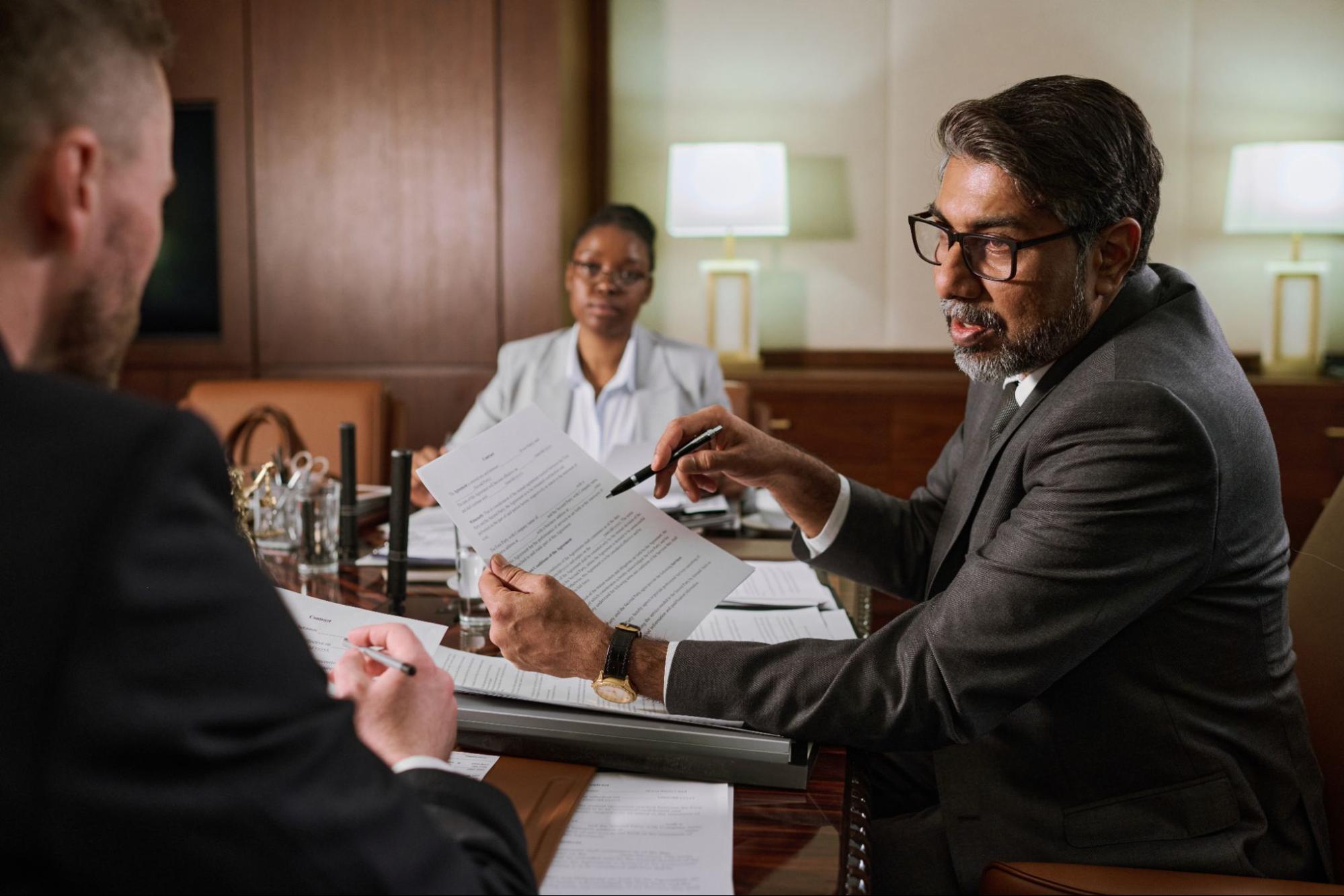 A business litigation attorney going over details of a contract dispute case with his client.