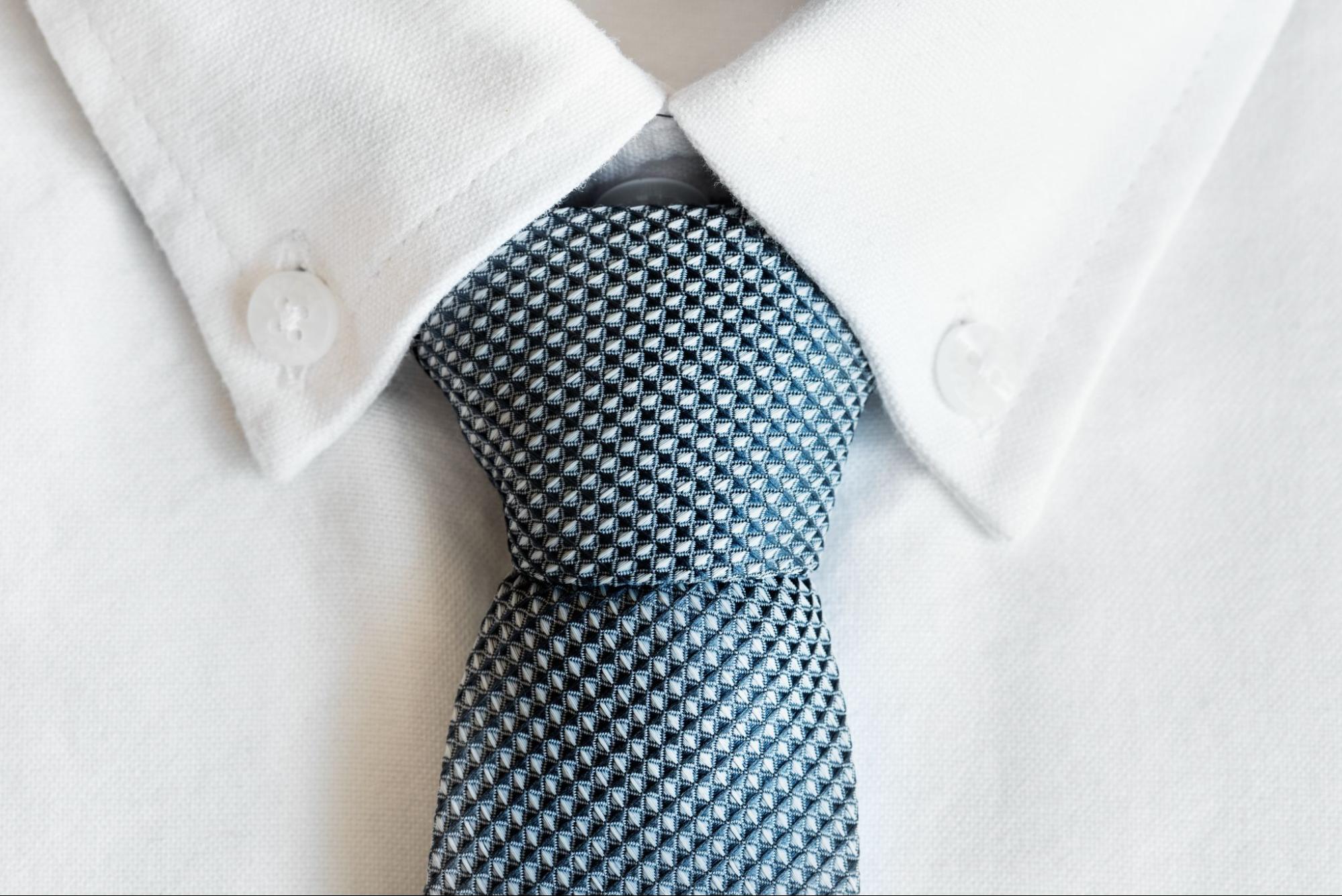 The close up image of a tie being worn by a person who needs to speak to a white-collar lawyer.