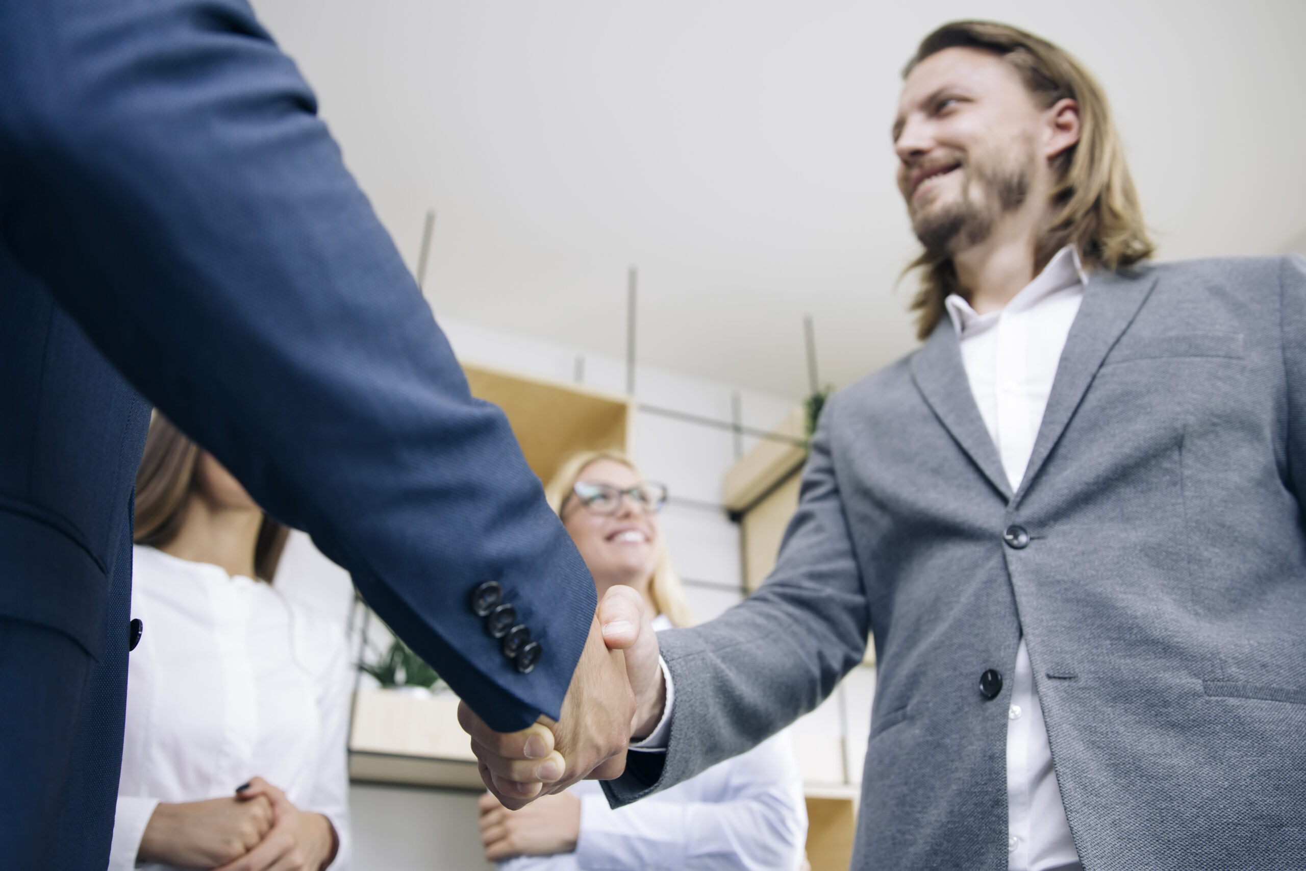 A boss shaking hands with an employee after learning how to properly handle employer/employee disputes.